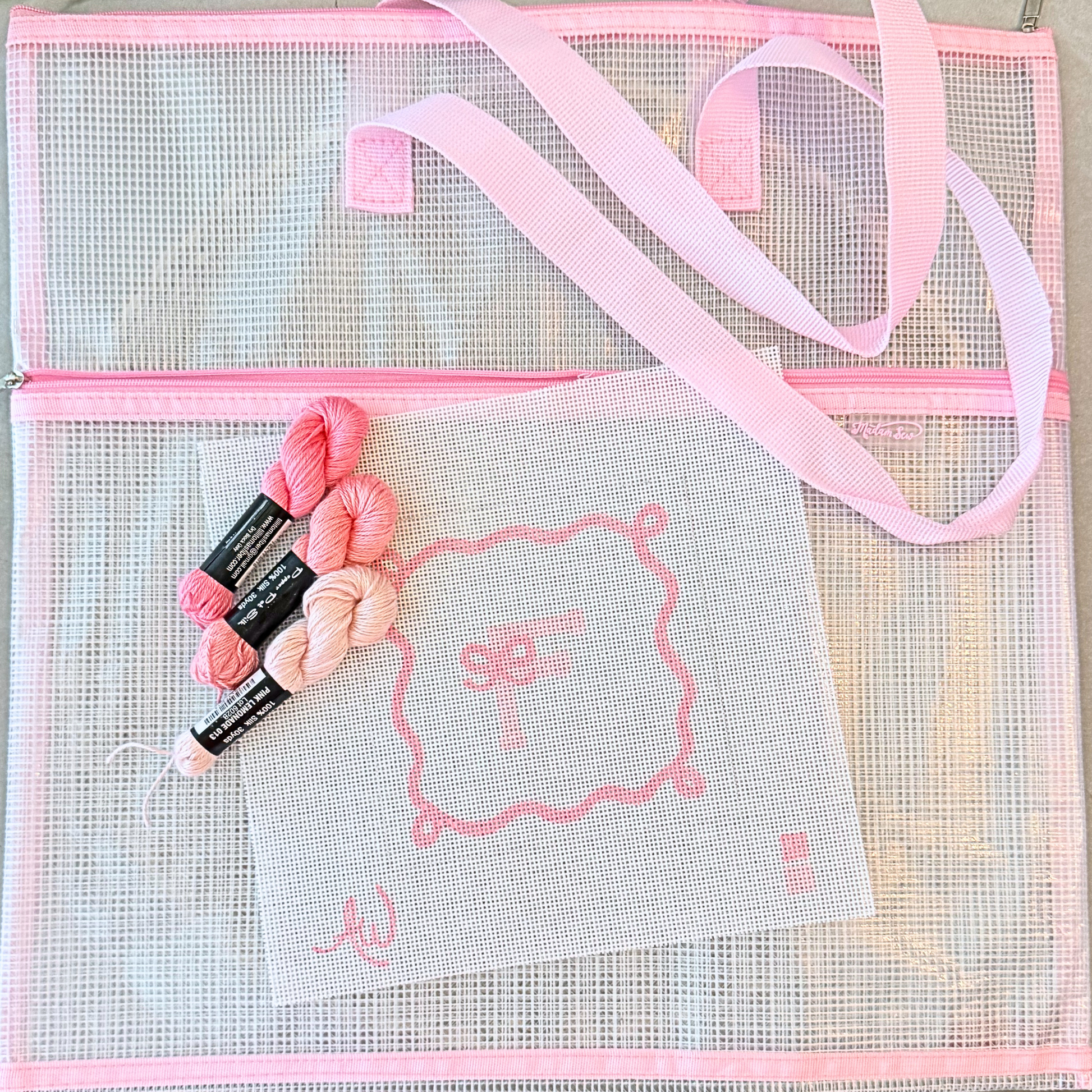 Madame Sew pink mesh needlepoint project bag holding canvas threads and stitching supplies