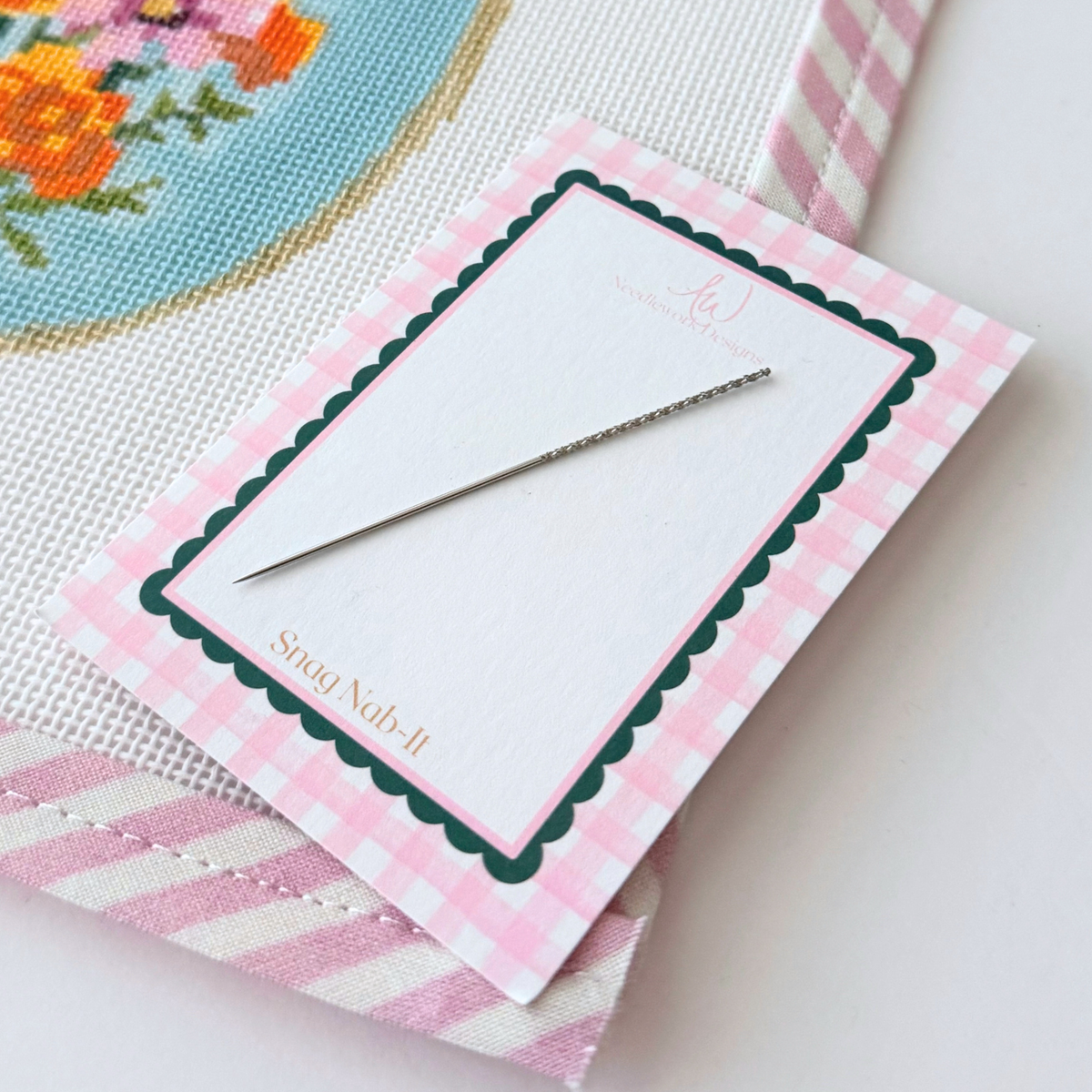 Using a Snag Nab-It tool to repair a loose thread on needlepoint canvas, the tool to fix a stitch