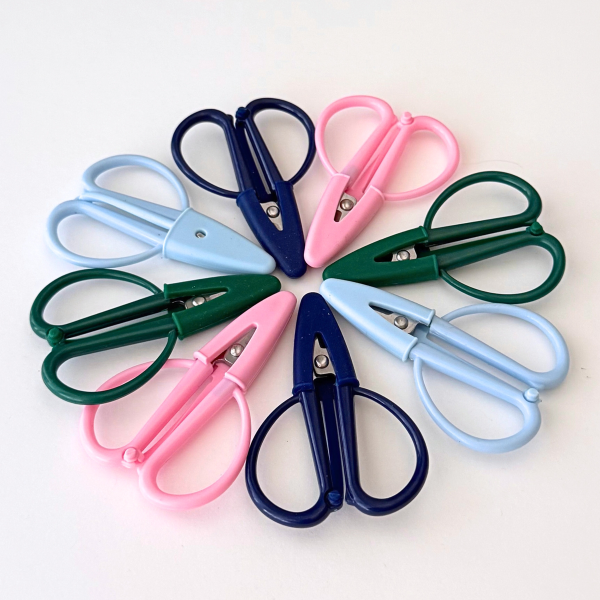 Mini needlepoint thread scissors in pink blue navy and green with attached blade covers