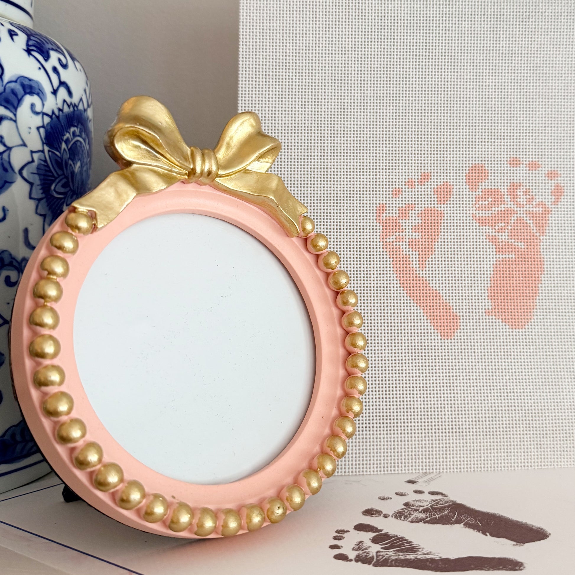 Personalized baby footprint needlepoint canvas created from a newborn’s footprints with a coordinating pink keepsake frame, hand-painted on 18 count needlepoint canvas.