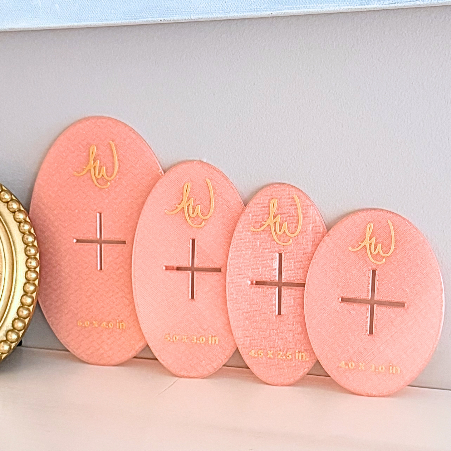 Oval needlepoint stencil set pictured on a mantle.