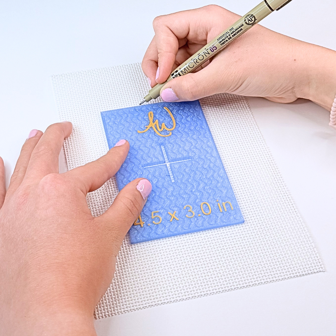 Needlepoint stencil being used to mark a needlepoint canvas.